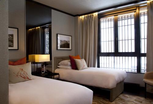 a hotel room with two beds and a window at Kasara Niseko Village Townhouse - Small Luxury Hotels of The World in Niseko