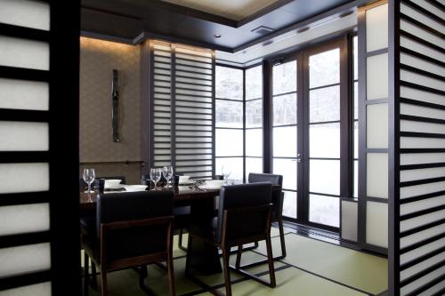 a dining room with a table and chairs and windows at Kasara Niseko Village Townhouse in Niseko