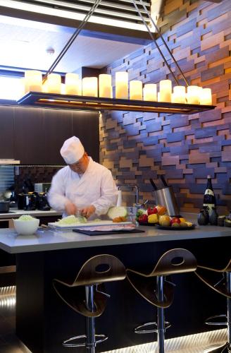 a chef preparing food in a restaurant kitchen at Kasara Niseko Village Townhouse in Niseko