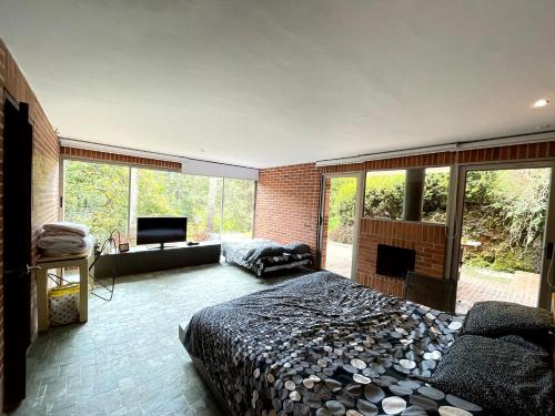 - une chambre avec un grand lit et une cheminée dans l'établissement Casa 38 de la Parcelación Lagos de Pontezuela, à El Retiro