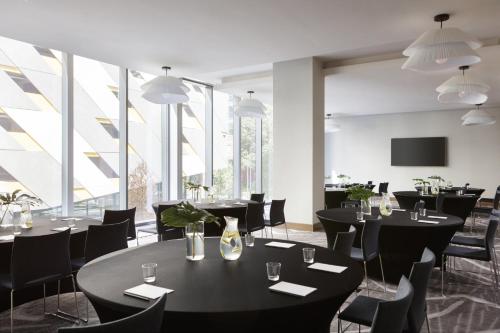 a restaurant with black tables and chairs and large windows at Kimpton Shane Atlanta by IHG in Atlanta