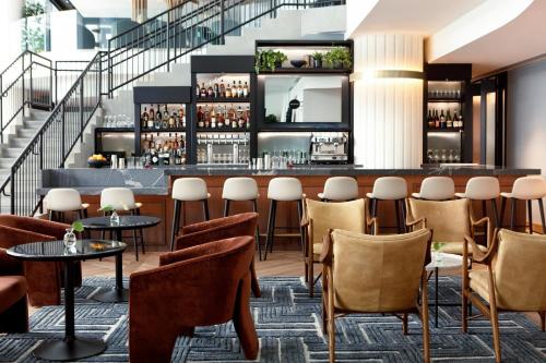 a restaurant with a bar with chairs and tables at Kimpton Shane Atlanta by IHG in Atlanta