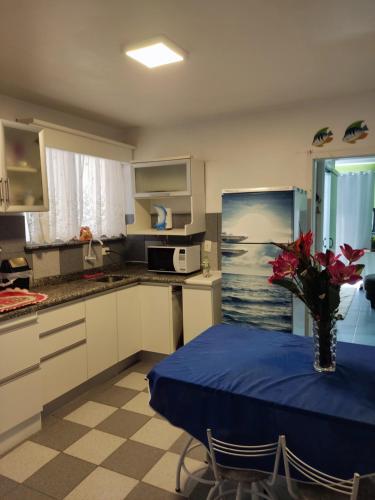 una cucina con un tavolo con un vaso di fiori sopra di Apartamento 103 Praia do Ervino - SFS a São Francisco do Sul