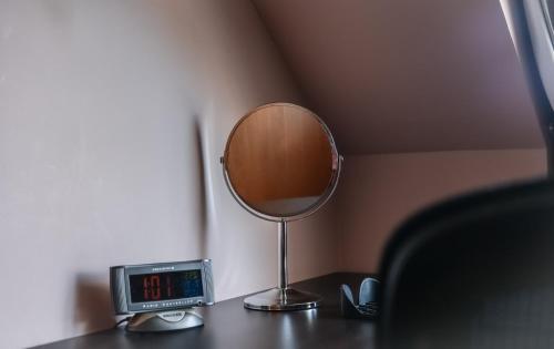 a mirror and a clock on a table at Nort Bode Apartments in Lerwick