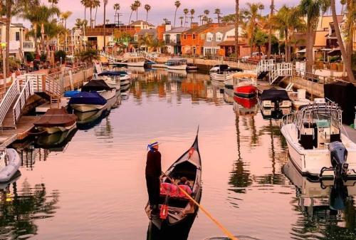 a man in a gondola in a harbor with boats at Beautiful 2 Story Right by the Water, Ocean View in Long Beach