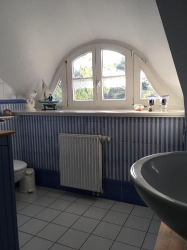 a bathroom with a sink and a window and a tub at Ferienwohnung zur Brake in Wieck