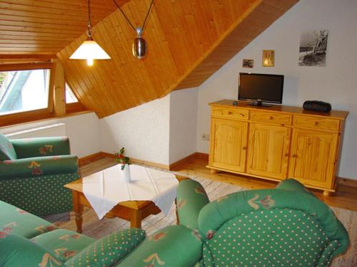a living room with green chairs and a table at Pension Martens - Gaubenwohnung in Wieck