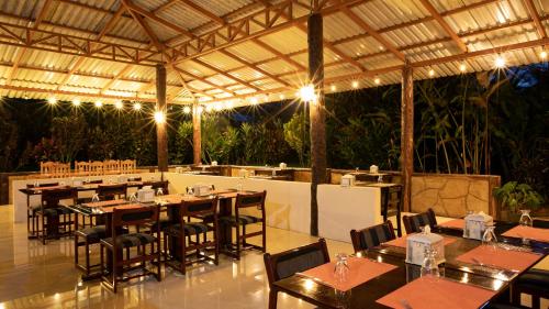 a restaurant with tables and chairs and a bar at Orquideas Boutique Hotel in Fortuna