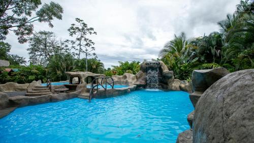 a pool in a resort with a water slide at Orquideas Boutique Hotel in Fortuna