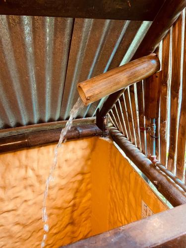 a stream of water coming out of a metal ceiling at The Mudhouse Hostel Mompiche in Mompiche