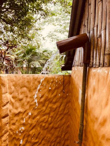 a water faucet with water coming out of it at The Mudhouse Hostel Mompiche in Mompiche