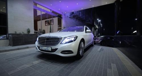 a white car parked in front of a building at Laten Suites Al Salim Plaza in Jeddah
