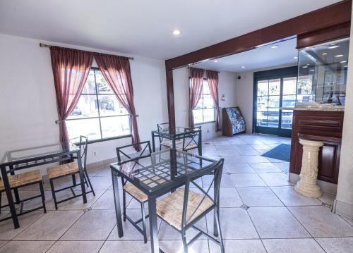 a dining room with a table and chairs and windows at Hospitality Inn in San Bernardino