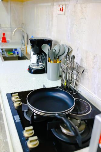 a stove top with a frying pan on top of it at Elite Luxury Apartments Kilimani - A 2 Bedroom Oasis of Serenity in Nairobi