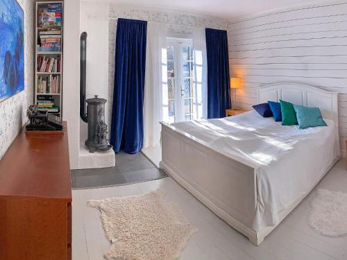 um quarto com uma grande cama branca com almofadas azuis e verdes em Holiday home HANINGE II em Haninge