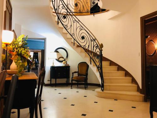 a staircase in a living room with a table and chairs at La plaine de l'Angelus in Chailly-en-Bière