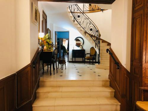 a hallway with stairs leading to a dining room at La plaine de l'Angelus in Chailly-en-Bière