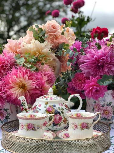 a table with two tea cups and a bouquet of flowers at La plaine de l'Angelus in Chailly-en-Bière