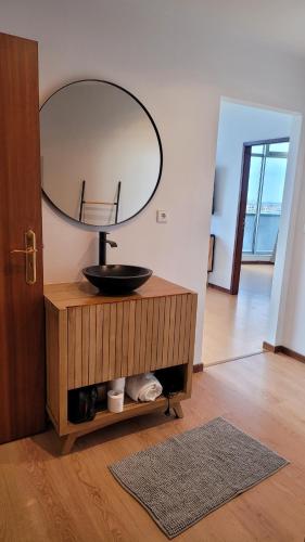 a bathroom with a sink and a mirror on a cabinet at Apartment T1 - Porto in Porto