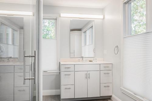 a white bathroom with a sink and a mirror at Peace Among the Pines in Wellfleet