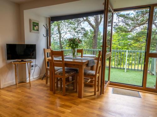 une salle à manger avec une table, des chaises et une grande fenêtre dans l'établissement Ledi, à Linlithgow