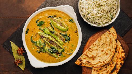 a table with a bowl of soup and a bowl of rice at InterContinental Marine Drive Mumbai by IHG in Mumbai