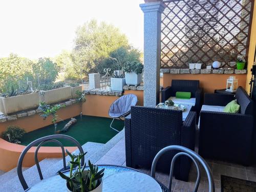 um pátio com mesas e cadeiras e um jardim em Apartment M&J - Valledoria - LA Muddizza - Free WI-FI em Valledoria
