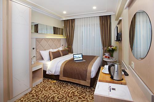 a hotel room with a bed with a laptop on it at Alpinn Hotel Istanbul in Istanbul