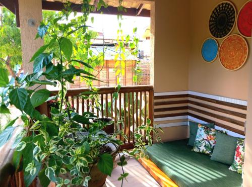 uma varanda com um banco e uma janela com plantas em #residencialvillajeri - CASA térrea com VARANDA, máq de lavar, 300m da PRAIA em Jericoacoara