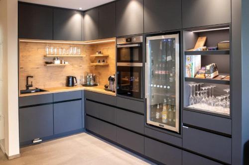 una cocina con armarios negros y una encimera en PRIMERA Apartments, en Singen