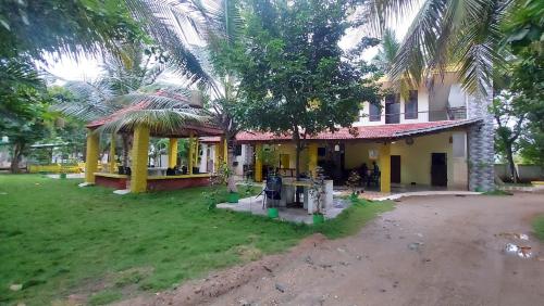 a house with a palm tree in front of it at Holiyday in VGF Farm House in Dānishpet