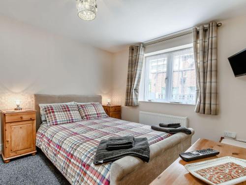 a bedroom with a bed and a table and a window at Cozy Lodge in Barton-upon-Humber