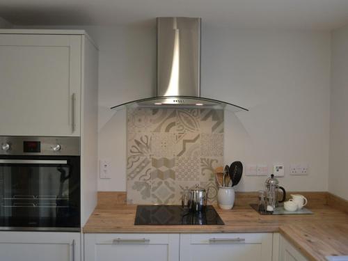 a kitchen with a sink and a stove top oven at The Cottage 47 in Aird Tong