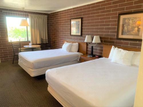 a hotel room with two beds and a window at Oquirrh Mountain Inn in Tooele