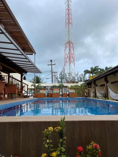 a large swimming pool with a tower in the background at Pousada Lua Nova Charmosa Pipa in Pipa