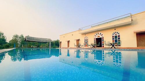 a swimming pool in front of a building at Anantvan Ranthambore By Asapian Hotels in Khilchipur