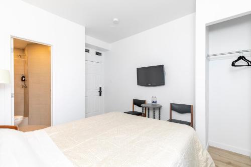 a bedroom with a bed and a tv on the wall at hotel le coach in Montréal