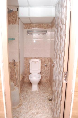 a bathroom with a white toilet in a stall at Adhi Residency in Kanchipuram