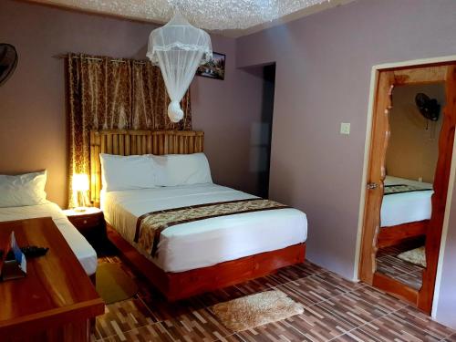 Dormitorio pequeño con cama y espejo en Mesmerize Guest House, en Port Antonio