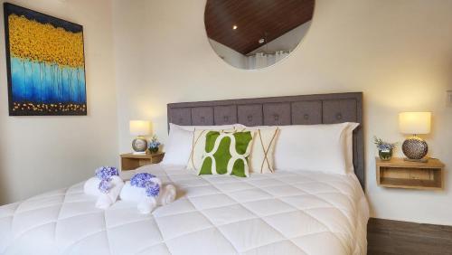 a bedroom with a large white bed with two stuffed animals on it at Rio Verde by Villa Alejandro in Boquete