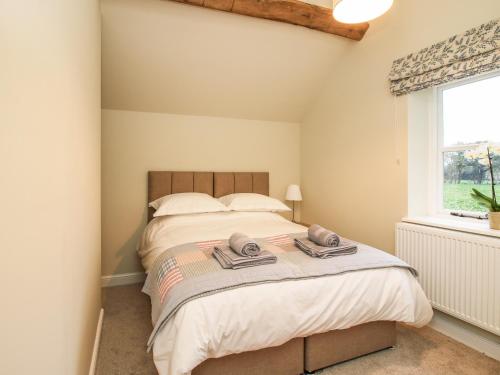 um quarto com uma cama com duas toalhas em The Barn em Shrewsbury