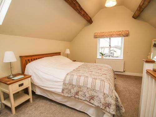 a bedroom with a bed and a window at Cow'ouse in Shrewsbury