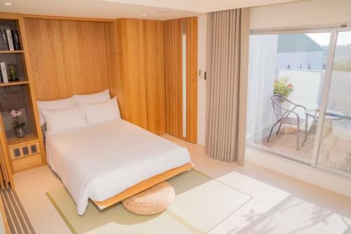 um quarto com uma cama e uma grande janela em 台南安平Viva漁樂活民宿 em Anping