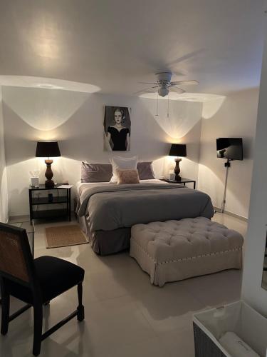 a bedroom with a bed and a chair and lamps at Pied-à-Terre Center of Tijuana in Tijuana