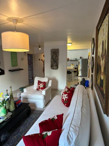 uma sala de estar com um sofá branco e almofadas vermelhas em Pied-à-Terre Center of Tijuana em Tijuana