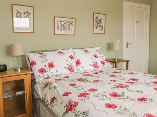 Lanton的住宿－Lantonhall West Wing，一间卧室,床上有红色的鲜花
