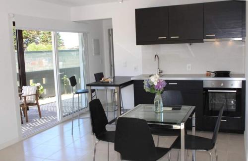 uma cozinha com mesa e armários pretos e uma sala de jantar em Luces de la Paloma em La Paloma