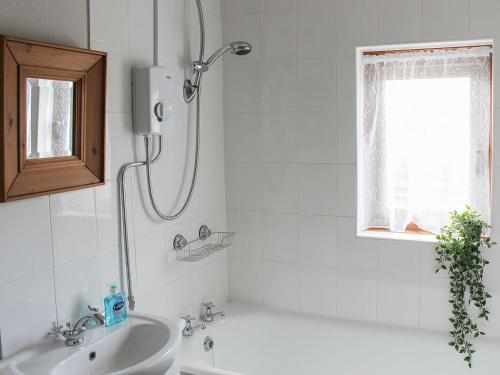 a bathroom with a tub and a sink and a shower at Clematis Cottage in Penrith