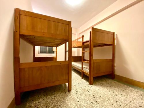 2 beliches num pequeno quarto com uma janela em Lee's Guesthouse em Fengyuan