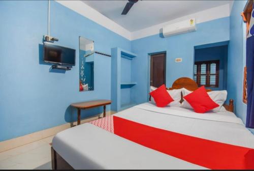 1 Schlafzimmer mit 2 Betten und einem TV an der Wand in der Unterkunft Labanya Lodge in Konark